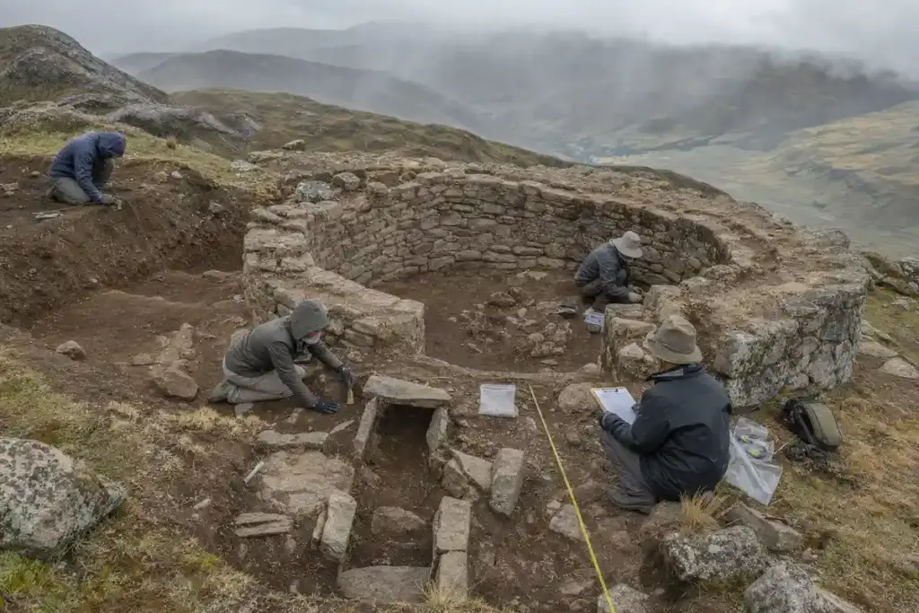 Archeologi scavano una struttura circolare in pietra sulle Ande, con metro a nastro e strumenti sul terreno