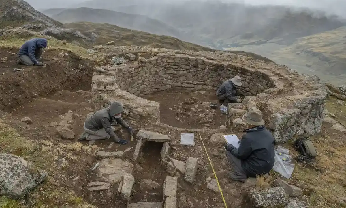 Archeologi scavano una struttura circolare in pietra sulle Ande, con metro a nastro e strumenti sul terreno