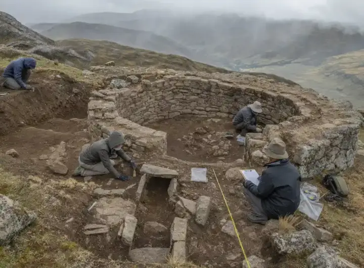 Archeologi scavano una struttura circolare in pietra sulle Ande, con metro a nastro e strumenti sul terreno